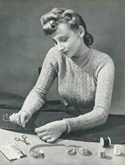 Needle Gallery: Woman tacking a hem before stitching it