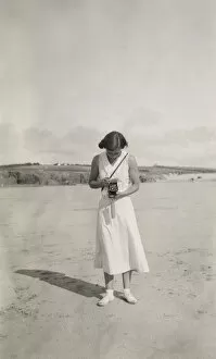 Woman taking a photograph on the beach