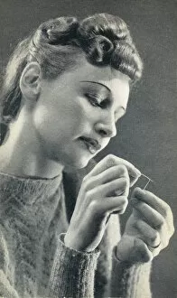 Woman threading a needle