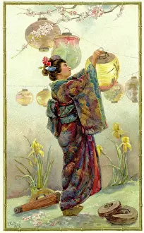 Woman in traditional dress lighting Japanese lanterns