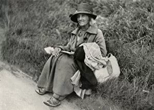 Tramps Gallery: Woman tramp sitting at side of road