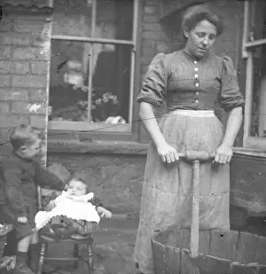 Woman using a dolly tub in a back yard, South Wales