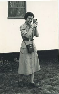 Cine Collection: A woman using what looks to be a cine camera, probably a Bell and Howell 252