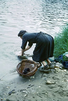 Woman washing clothes in a river