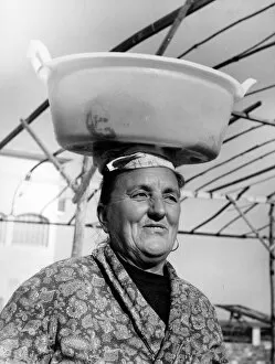 Images Dated 28th November 2017: Woman with wet washing on her head, Italy