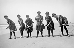 Women on the beach in period bathing costumes wring out wate Women on the beach in period bathing costumes wring out wate