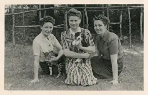 Cedar Prints: Three women with cat and puppy in a garden