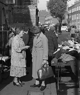 Two women chat at second hand clothes stall, London
