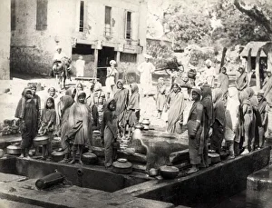 Women collecting water from a well, India