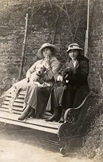 Two women and their dogs in a garden