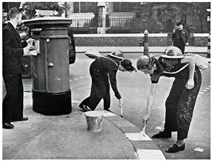 Women painting kerbside for blackouts, September 1939