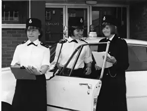 Three women police officers standing by a car, London