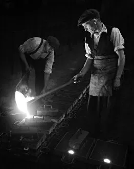 Images Dated 27th April 2021: Workers in foundry pouring molten metal