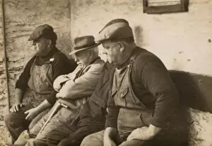 Four workmen sitting on a bench