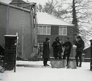 Four workmen stop for a cup of tea on a snowy day