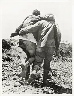 World War II US soldier helped towards the rear