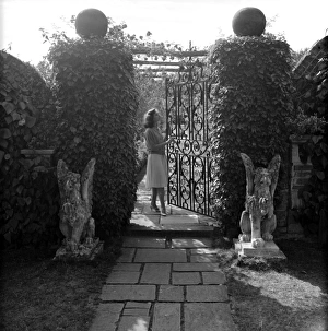 Images Dated 22nd January 2016: Wrought iron gate in a garden with female model
