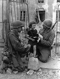 Landings Collection: WW2 - US Troops comfort a distressed child and puppy