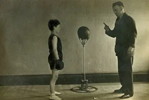 Instructing Prints: Young Boxer receiving instruction from his Trainer in a gym