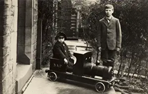 Young boy in a model train with his elder brother