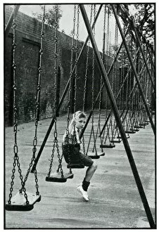 Images Dated 20th July 2019: Young boy alone on a playground swing 1939
