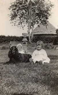 Sundial Prints: Two young children with a spaniel dog in a garden