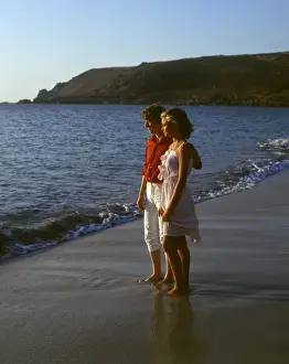 Twilight Prints: Young couple walking along a beach, West Country