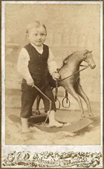 Stirrups Prints: Young German boy with rocking horse and whip