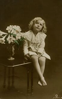 Lily Gallery: Young girl sitting on table with vase of flowers