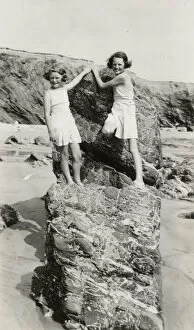 Insert Collection: Two young girls playing on the rocks on a Cornish beach