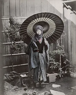 Young Japanese woman in winter costume with umbrella