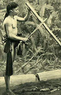 Young Kayan man making a blowpipe, Borneo, SE Asia