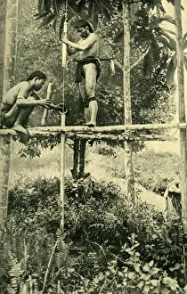 Young Kayan man making a blowpipe, Borneo, SE Asia