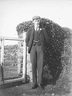 Young man standing by a gate