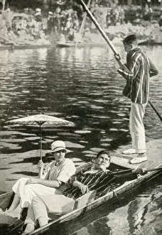 Three young people punting on a river, England