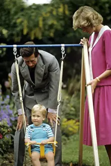 A young Prince William on a swing next to his parents