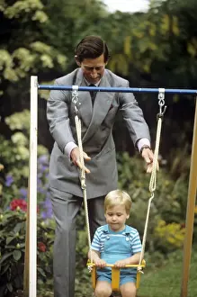 1985 Prints: Young Prince william on a swing, pushed by Prince Charles