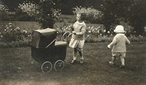 Pram Collection: Two young siblings playing with a beautiful toy pram