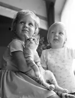 Two young sisters and their pet cat