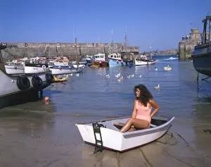 Gulls Prints: Young woman in a boat at Newquay harbour, Cornwall