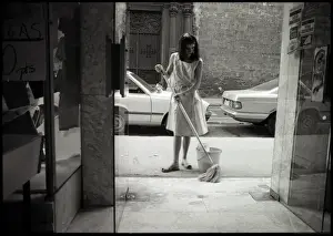 Young woman cleaning in doorway, Valencia, Spain