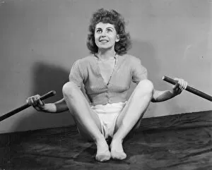 Exercising Collection: A young woman exercising with a pair of oars. Date: 1940s