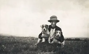Young woman in a field with two terrier dogs