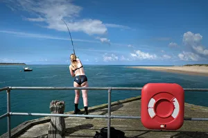 Aberdovey Gallery: A young woman fishes from the pier at Aberdovey (Aberdyfi)