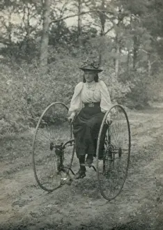 Young woman riding an early form of bicycle