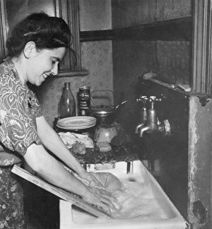 Dinner Collection: Young woman washing clothes at a sink